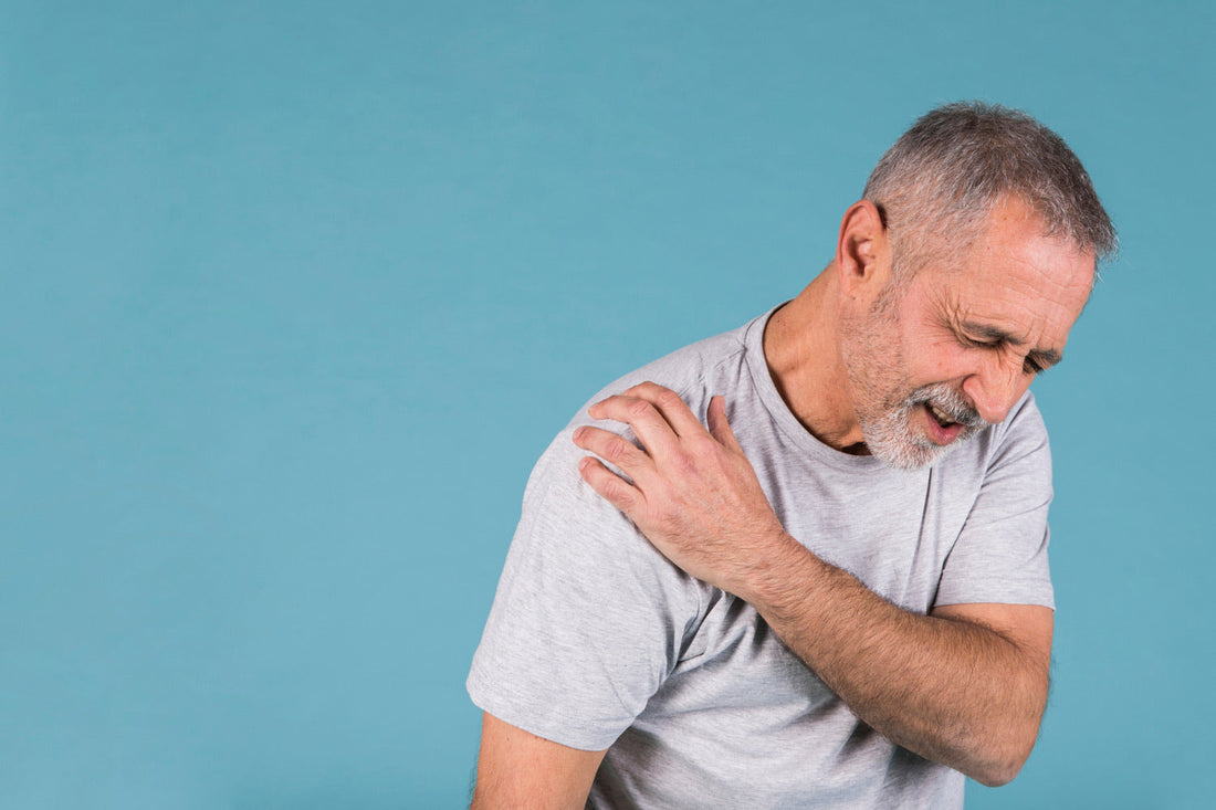 Man har synligt ont från frozen shoulder