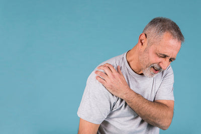 Man har synligt ont från frozen shoulder
