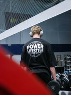 Svart T-shirt sedd bakifrån med Power Lifestyle-tryck och hörlurar