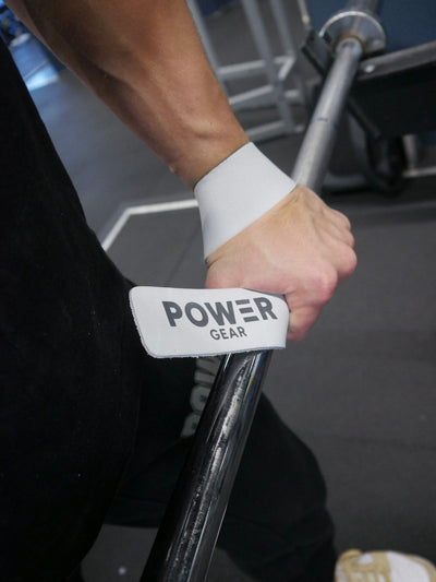 Vita läderlyftremmar med Power Gear-märke runt handleden