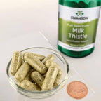 Mjölktistelkapslar i glas, med Swanson Full Spectrum Milk Thistle-burk synlig.